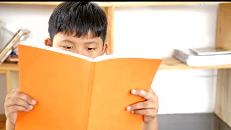 Cute-asian-children-reading-a-book-on-desk-in-the-room.-education-concept