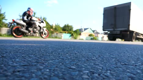 Truck-is-driving-along-an-asphalt-road.-Blurred-car-is-riding-at-the-highway-at-the-sunny-summer-day.-Low-angle-view-Close-up-Slow-motion