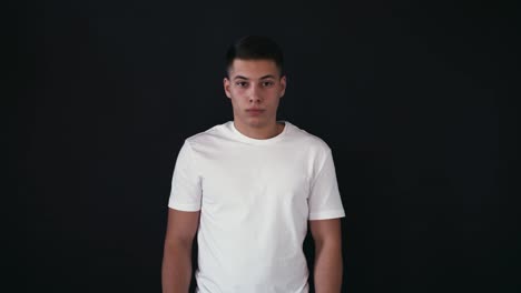 Calm-and-peaceful-guy-at-first-stand-and-looks-on-camera.-He-is-calm.-Suddenly-he-starts-to-scream-out-loud.-He-did-it-once-and-continue-to-look-calm-on-camera.-Isolated-on-black-background