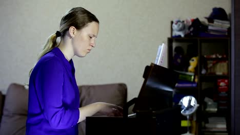 Teen-girl-plays-on-the-keyboard-of-the-digital-piano.