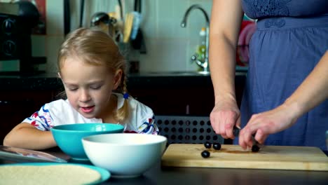 Mother-and-Daughter-Cutting-Olives--on-the-Kitchen