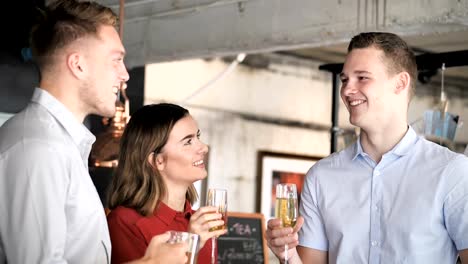 Erfolgreiche-junge-Geschäftsmänner-und-Geschäftsfrau-mit-Champagner-im-Büro,-Slow-Motion-zu-feiern.