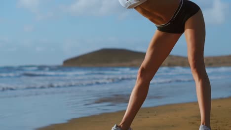 Mujer-que-estira-las-piernas-y-los-isquiotibiales-haciendo-pose-estiramiento-permanente-curva-adelante-Yoga-en-la-playa.-Mujer-de-gimnasio-relajarse-y-practicar-deporte-y-yoga-en.