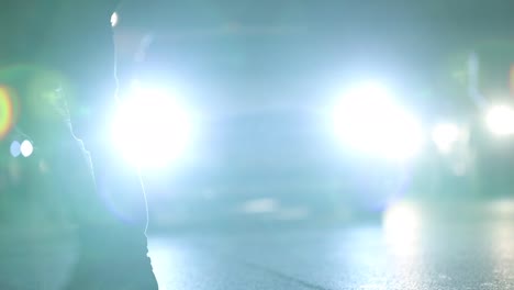 Crowd-of-Pedestrians-feet-crossing-street-at-night-with-lens-flares-hitting-camera-in-the-background