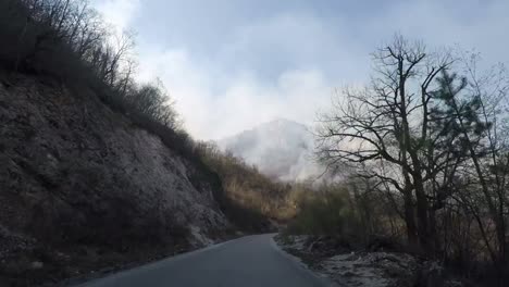 A-shot-from-a-car-at-a-mountain-road-showing-a-mountain-in-flames