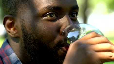 Hombre-africano-americano-hermoso-sonriendo,-coqueteando-y-bebiendo-vino,-primera-fecha