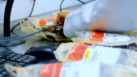 Laboratory-technician-scanning-plasma-bags-with-barcode-scanner-4k