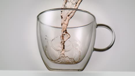 Fruity-hot-tea-softly-being-poured-into-a-glass-in-slowmotion