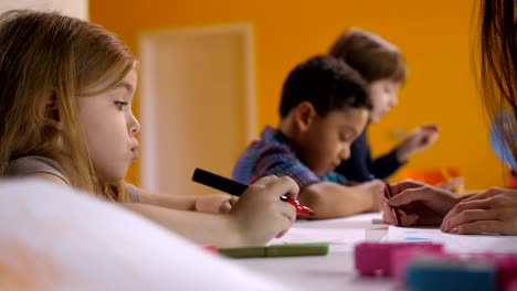 Cute-engrossed-little-girl-drawing-at-art-lesson