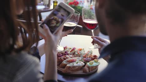 Closeup-Woman-Taking-Photos-On-Phone-Of-Food-In-Restaurant