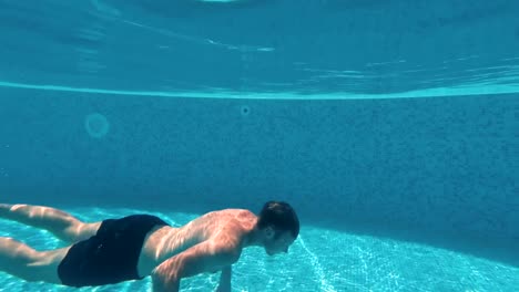 Young-guy-swims-underwater-in-a-swimming-pool