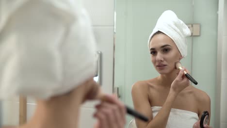 Make-up.-Frau-Auftragen-von-Puder-auf-Gesichtshaut-im-Badezimmer