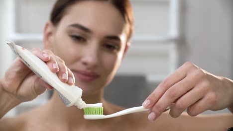 Zähne-Hygiene.-Frau-Anwendung-Zahnpasta-auf-die-Zahnbürste-Closeup