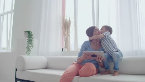 Mother-and-son-playing-with-digital-tablet-at-home.-Young-mother-with-her-5-years-old-smiling-with-digital-tablet-at-home.