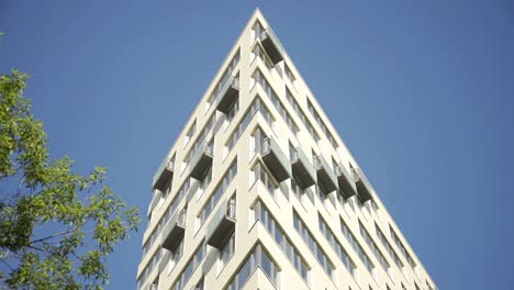 Außenaufnahme-eines-Mehrfamilienhauses.-Wohnhaus-außen-mit-blauem-Himmel-Hintergrund.-Das-Gebäude-verfügt-über-außen-mit-kleinen-Balkonen