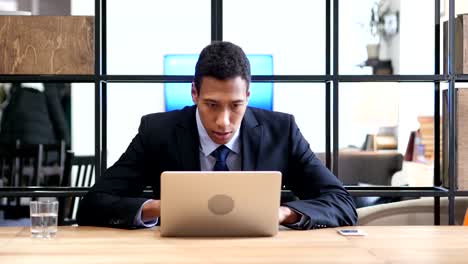 Black-Businessman-Upset-by-Loss-while-Working-Online