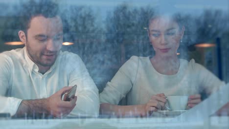 Woman-getting-bored-in-cafe-while-her-boyfriend-is-busy-with-the-phone