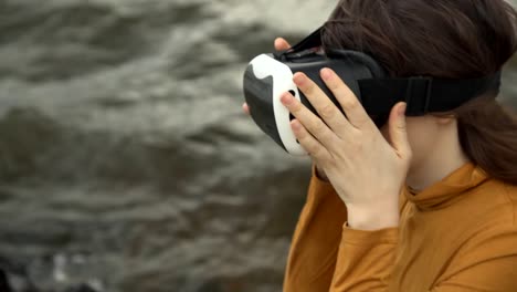 A-young-woman-uses-virtual-reality-glasses-next-to-strong-waves.