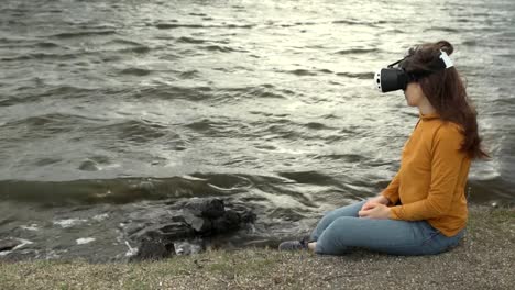 A-young-woman-uses-virtual-reality-glasses-next-to-strong-waves.