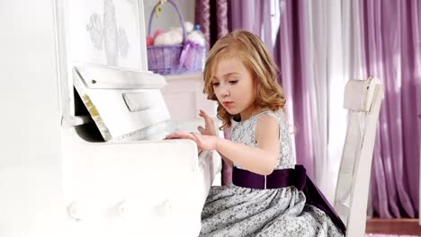 girl-plays-piano,-,-girl-in-a-dress-with-a-purple-belt,-slow-motion