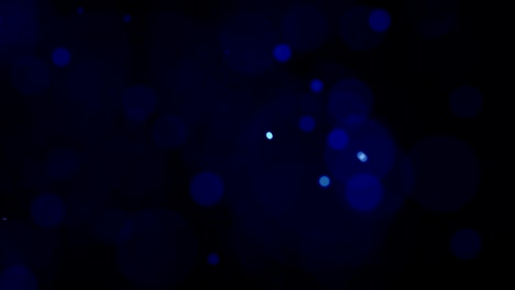 Blue-Colored-Cinematic-Looking-Particles-With-Turbulence-Motion-Moving-In-Front-Of-Camera-With-Shallow-Dof-On-Black-Background