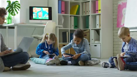 Kinder-im-Vorschulalter-mit-Tabletten-bei-Unterrichtsstunde-mit-Lehrerin