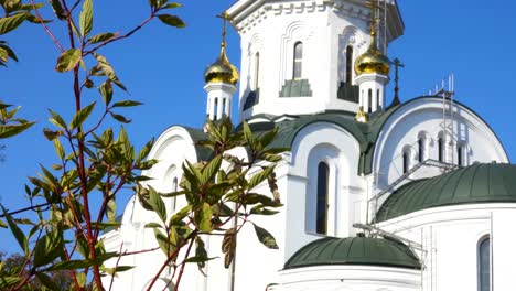 Dome-of-the-Church-and-leaves.-The-silhouette-of-the-cross-and-church-bell-tower-in-sunrise.-An-autumn-windy-day-shakes-the-leaves-of-the-trees.