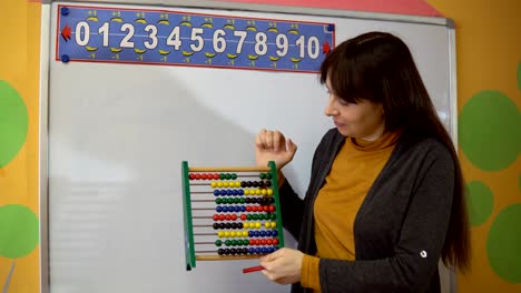 Female-teacher-stand-near-blackboard-in-elementary-school-teaching.