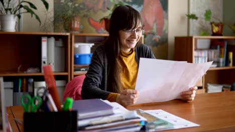 The-young-teacher-in-glasses-in-the-classroom-checking-independent-tests.