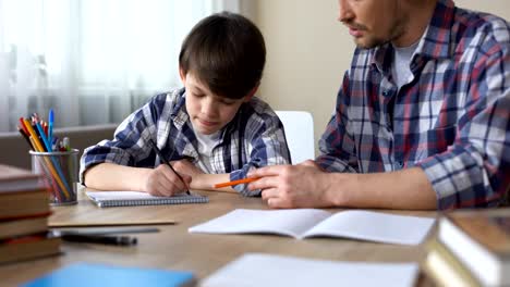 Fürsorglicher-Vater-helfen,-seinen-kleinen-Sohn-zu-tun,-Hausaufgaben,-Väter-Unterstützung,-Bildung