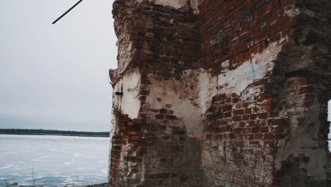 Inside-destroyed-orthodxal-chapel,-red-bricks-walls,-cold-cloudy-day