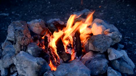 Lagerfeuer-in-ein-Lagerfeuer-von-Steinen-im-freien-in-der-Abenddämmerung