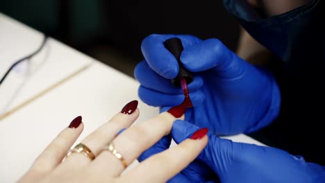 Polishing-nails-with-red-nail-polish-in-the-beauty-salon.