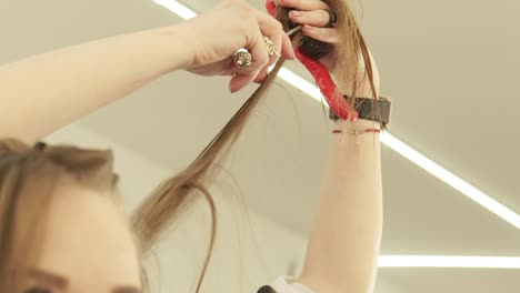 Hairdresser-cutting-long-hair-with-professional-scissors-in-hairdressing-salon.-Close-up-haircutter-making-woman-haircut-with-scissors-in-beauty-salon