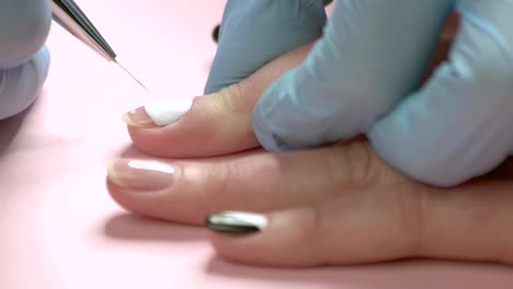 Close-up-manicure-master-drawing-on-nails.