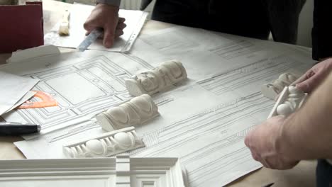 Hands-of-male-designer-putting-white-molding-samples