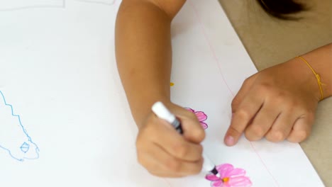 The-asian-female-kid-drawing-and-painting-his-art,-color-magic-pen-on-paper.