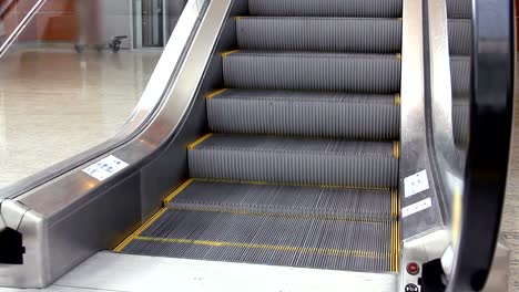 Empty-escalator-stairs-moving-up-with-logo-warning-in-modern-office-building