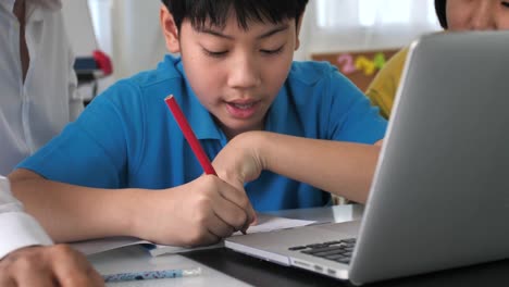 Tutor-room-children-in-class-learning-on-laptop-computer-with-teacher.-4K-Slow-motion-Asian-child-learning-with-teacher-at-home.