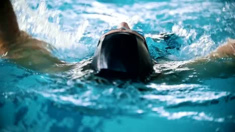 Behinderte-Mensch-schwimmt-auf-der-Rückseite-in-einem-Schwimmbad-in-Richtung-der-Kamera.-Nächster-Nähe-erschossen.-Slow-motion