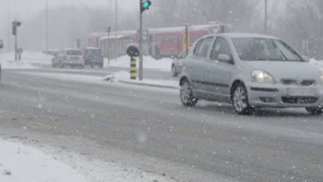 Zeitlupe:-Stadtverkehr-fahren-auf-der-rutschigen-Straße-in-gefährlicher-Schneesturm.