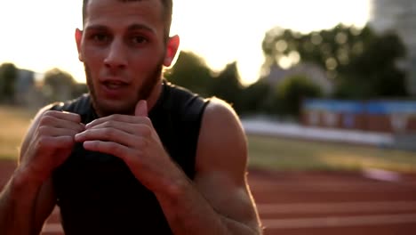 Accelerated-handhelded-footage-of-a-young-boxer-exercising-outdoors.-Portrait-of-a-man-boxing-with-invisible-opponent,-punching.-Front-view