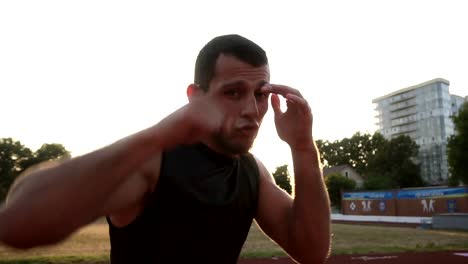 Accelerated-handhelded-shot-of-a-young-boxer-exercising-outdoors.-Portrait-of-a-man-boxing-with-invisible-opponent,-punching.-Low-angle-footage