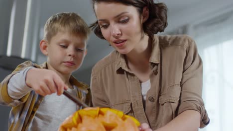 Mother-and-Son-Carving-Pumpkin-Together-at-Home