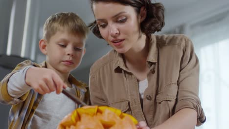 Madre-e-hijo-talla-calabaza-juntos-en-casa