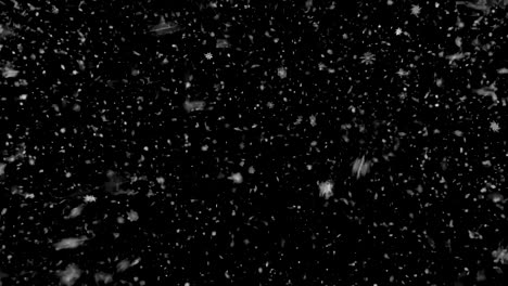 Heavy-snowfall-on-a-black-background-for-transferring-to-a-photo-or-video-of-winter-weather.-looped