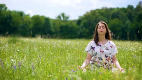 Frau-sitzt-in-Lotus-Pose-meditieren-im-Freien,-Wind-bewegt-sich-Haare,-Einssein-Natur