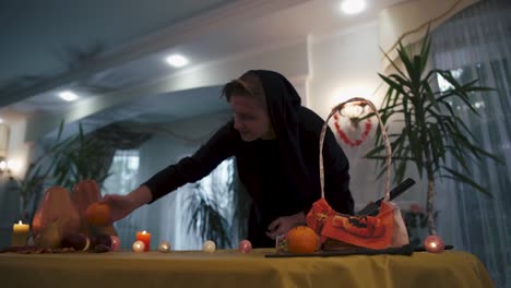 Halloween.-Magician-in-the-black-overalls-comes-to-the-festive-table.