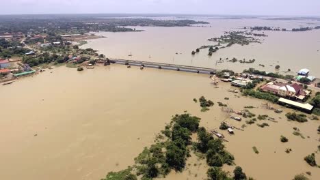 Drone:-volar-hacia-adelante-un-puente-de-concreto-que-atraviesa-el-río-inundado-en-zona-rural