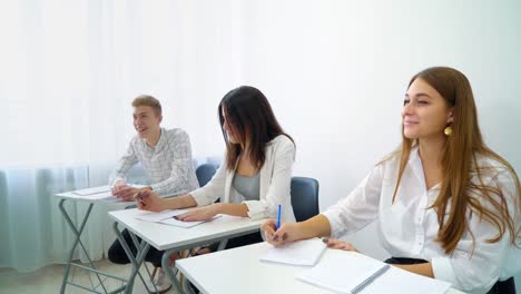 young-smart-girl-from-student-group-answering-mentor's-question-in-high-school-classroom